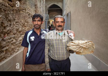 ISFAHAN, IRAN - AUGUST 20, 2016: Two bread sellers pose in Isfahan with flatbread, on iranian food supply, commerce in Iran, where staple bread, infla Stock Photo