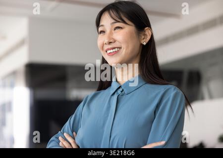 Cheerful young Asian business leader woman standing in office Stock Photo