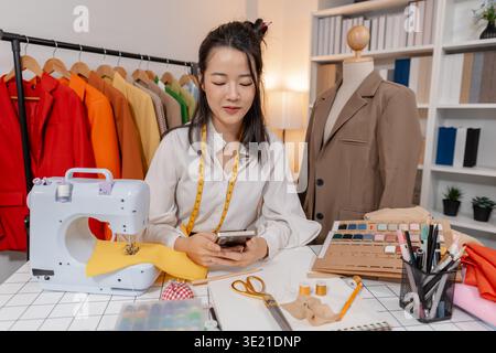 Clothing designer working with sewing machine while developing apparel design and preparing garments in fashion studio, focusing on craftsmanship and Stock Photo