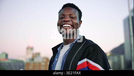 Black man, smile and fashion in city for portrait with sky, space and confidence with trendy outfit. African person, happy and student in urban town Stock Photo