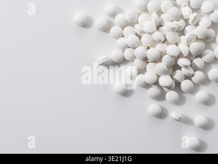 Top view of white pills or supplement tablets on white background with copy space Stock Photo