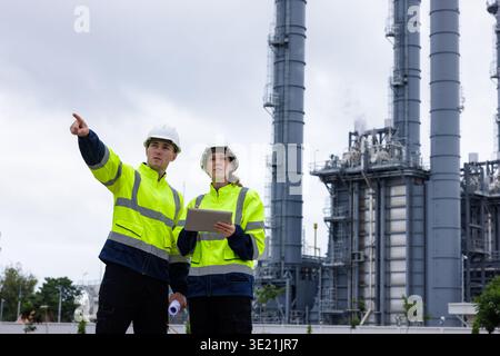 Petrochemical engineers teamwork working together at petroleum oil refinery industry area. Industrial technician worker maintenance inspect Stock Photo