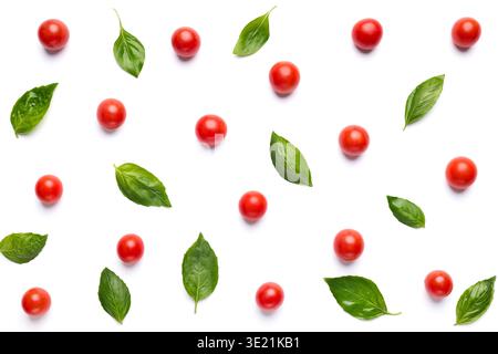 Colorful pattern of tomatoes and basil leaves on white background Stock Photo