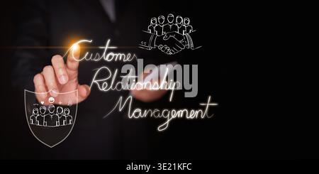 CRM customer relationship management concept. A businessman with a smartphone touches text with icons of a handshake with customers and a shield of pr Stock Photo