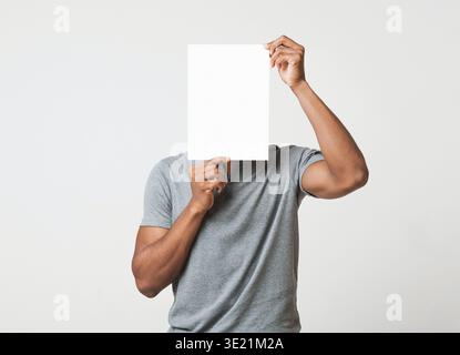 Man covering his face with empty white paper Stock Photo