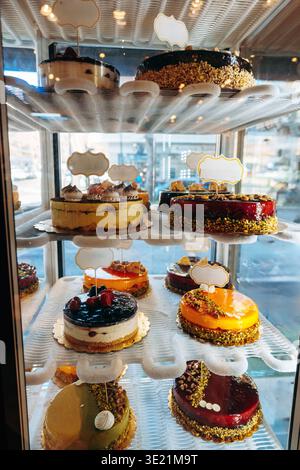 Display showcases various cakes in a bakery on a sunny day Stock Photo