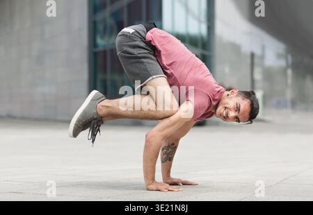 Young man doing handstand pose on the street Stock Photo