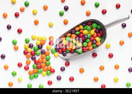 Scoop with colorful candies, isolated on white Stock Photo