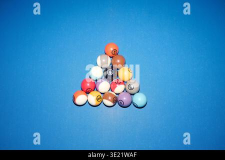 Billiard Balls Arranged in Triangle Formation on Blue Table Surface Stock Photo