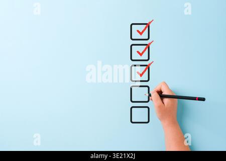 Hand checking checklist boxes representing task completion and productivity concept Stock Photo