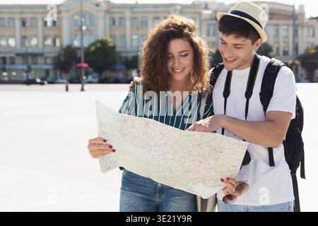Young couple traveling, reading map in the city Stock Photo