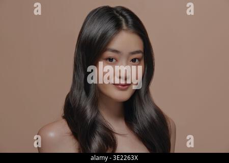 Beautiful young asian woman with clean fresh skin on beige background, Face care, Facial treatment, Cosmetology, beauty and spa concept, Asian women Stock Photo