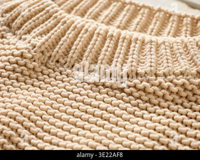 Close-up of a beige knitted fabric with ribbed and plain stitch patterns. Germany Stock Photo
