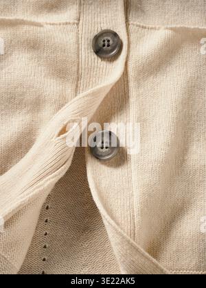 Close-up of a beige wool sweater with two grey buttons. Germany Stock Photo