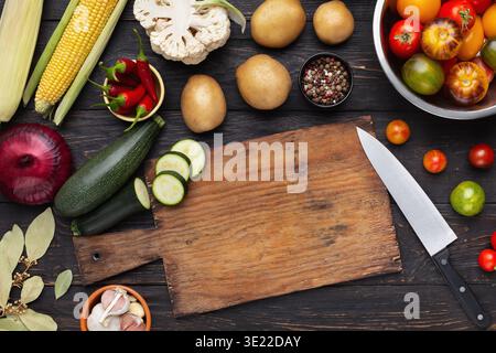 Vegetables assortment on kitchen table with cutting board Stock Photo