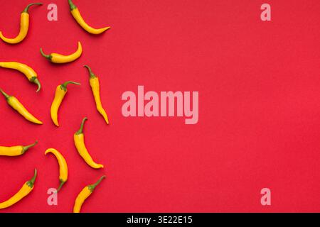 Hot yellow chilli peppers on red background Stock Photo