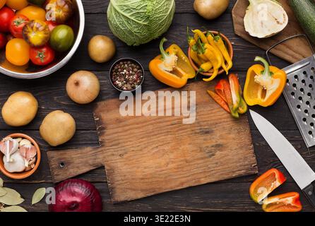 Vegetables assortment on kitchen table with cutting board Stock Photo