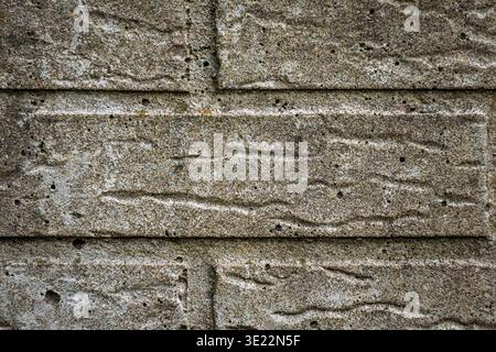 Close up of a grey concrete wall with visible pores and uneven rough texture. Stock Photo
