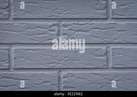 Close up of a light grey painted brick wall with rough textured surface. Clean minimal background with visible masonry pattern and neutral tones. Stock Photo