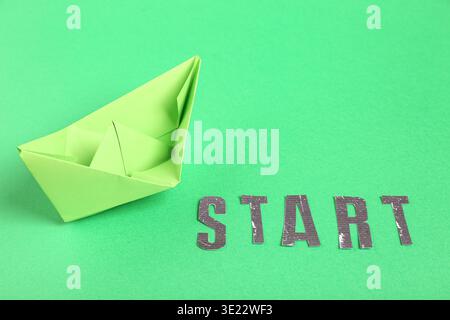 Origami boat with word START on green background Stock Photo
