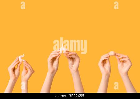 Female hands with human internal organ models on yellow background Stock Photo