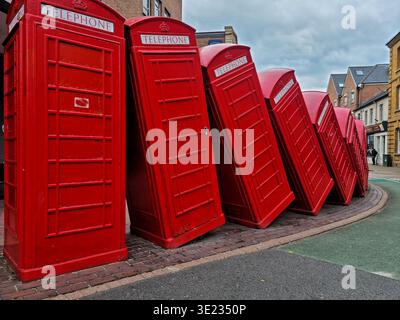 ‘Out of Order’ tumbling red telephone box sculpture in Kingston upon Thames, a striking public art installation of stacked British icons on Old London Stock Photo