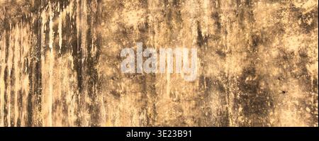 grunge wall texture with layered stains, erosion marks, and rough vertical streaks. Distressed surface with golden beige hues suitable for abstract ba Stock Photo