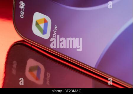 New York, USA - February 23, 2026: Google drive icon application on smartphone screen close up with pink reflection on pink background Stock Photo