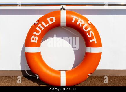 Build trust symbol. Concept words Build trust on beautiful orange lifebuoy. Beautiful white ship's board background. Business and build trust concept, Stock Photo