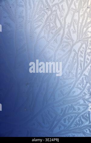 Hoarfrost forms an abstract ornament on a window pane Stock Photo