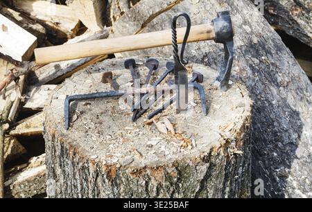 Hew ax and forged hardware on wooden deck near village smithy Stock Photo
