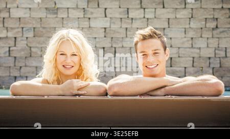 A young good-looking couple relaxing at the edge of a swimming pool, man, woman, 30, 35, years, swimming, swimming, relaxing, Bavaria, Federal Republi Stock Photo