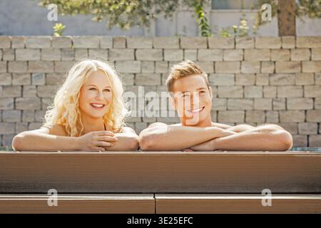 A young good-looking couple relaxing at the edge of a swimming pool, man, woman, 30, 35, years, swimming, swimming, relaxing, Bavaria, Federal Republi Stock Photo