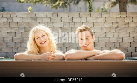 A young good-looking couple relaxing at the edge of a swimming pool, man, woman, 30, 35, years, swimming, swimming, relaxing, Bavaria, Federal Republi Stock Photo