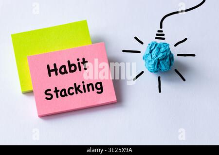 Habit Stacking written on colorful sticky notes. Business concept. Building new good habits and combining them with existing ones. A light bulb made f Stock Photo