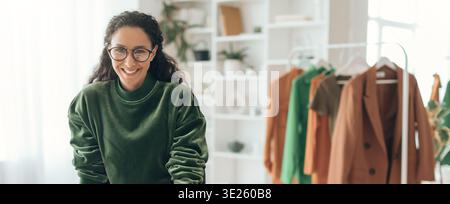 Fashion Designer Works on Clothing Collection in a Bright Studio During Daylight Hours Stock Photo