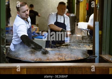 Chef cooking street food in a giant pan at Borough market Stock Photo