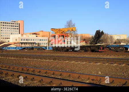 Heavy railway track-laying crane for maintenance and construction of railroad infrastructure. Specialized industrial vehicle stands on the tracks unde Stock Photo