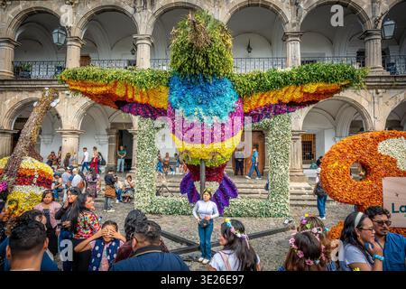 Festival De Flores - Antigua Guatemala - Giant bird-shaped sculpture covered in vibrant flowers towers over a lively crowd in Antigua Guatemala plaza Stock Photo