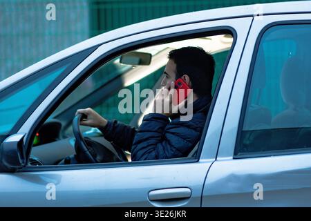 Man talking on mobile phone while driving car Stock Photo