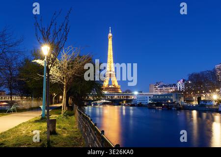 Paris, France-15 March , 2026 : The Eiffel Tower lit up at night with tree branches in the foreground. Paris, France. Stock Photo