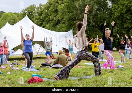 Diverse women enjoying a yoga class and healthy lifestyle during an outdoor retreat Stock Photo