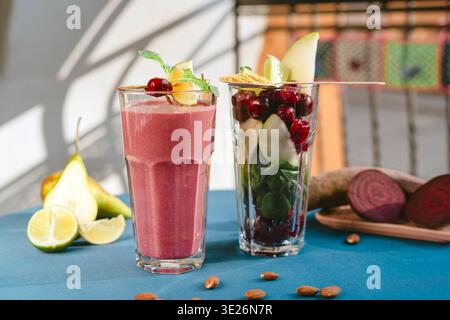 A fresh glass of beetroot juice with whole beets on a rustic wooden table. A healthy, vibrant red drink made from organic ingredients Stock Photo