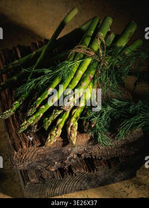 Bunch of Green Asparagus with Dill on Rustic Wooden Surface Stock Photo