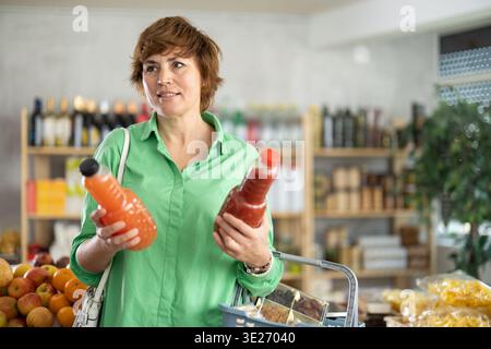 Adult woman choosing juices Stock Photo