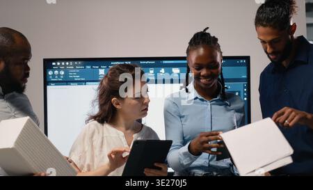 Portrait of real estate developers team planning a high density housing project, attention to sustainability and urban infrastructure growth. Blueprints for residential master plan. Stock Photo