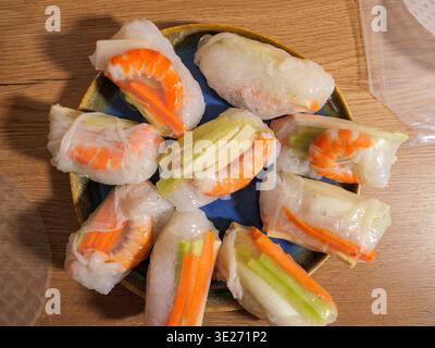 Homemade spring rolls made with rice paper, shrimp and fresh vegetables served on a plate. Healthy Asian-inspired food. Stock Photo