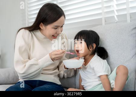 family time, breakfast, activities together during the holidays. Mother and daughter are having a meal together during the holidays. New home for fami Stock Photo