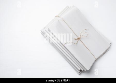 Stack of folded newspapers on white wooden table, top view. Mockup for design Stock Photo