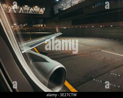 View of empty apron and terminal building from E175 jet window taxiing ...